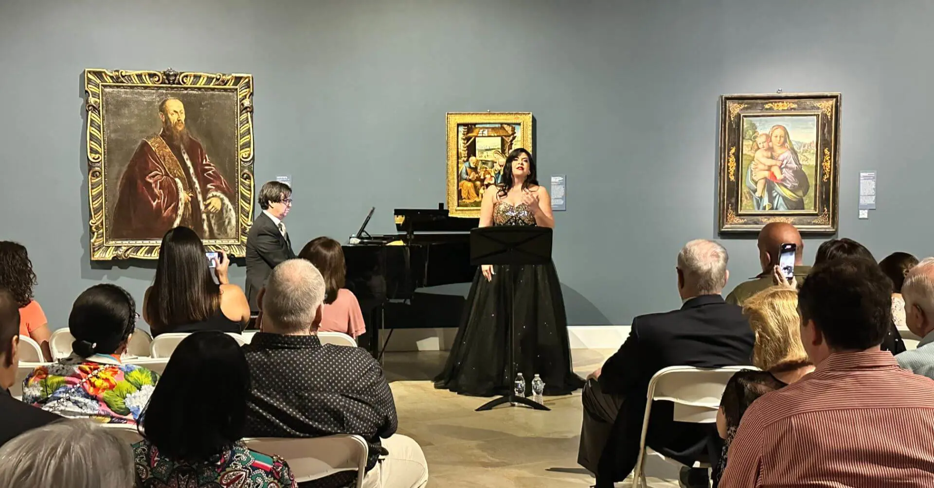 Singer performing accompanied by a piano with paintings in the background at the Saladrigas Art Gallery