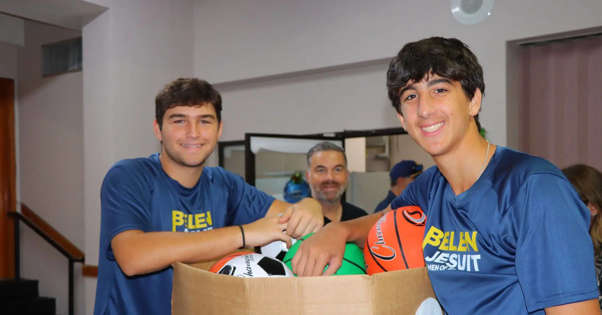 Belen Jesuit students with a box of sports balls for Reyes Magis Christmas.