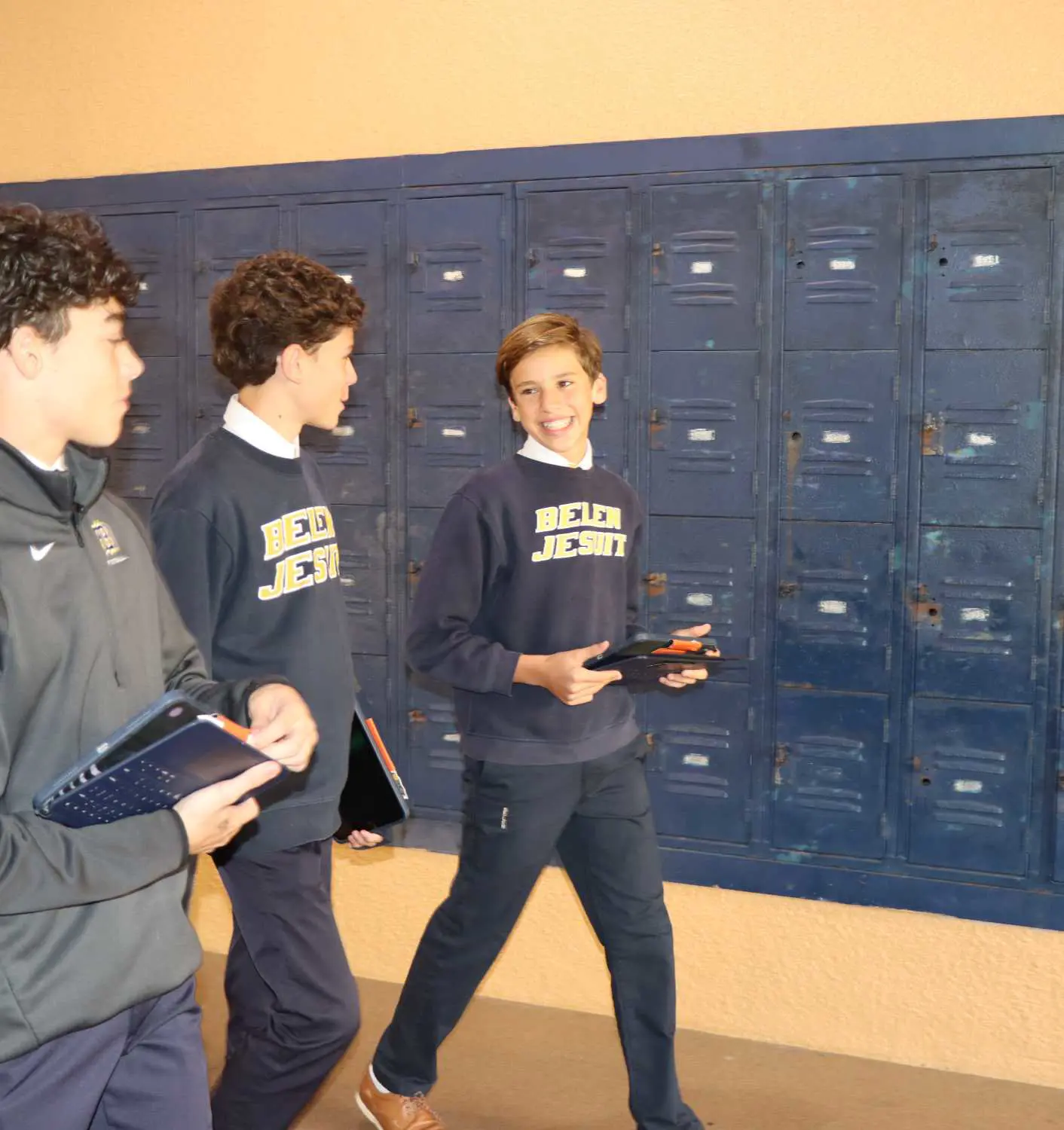 Christopher Peñate ’30 walking past school lockers with friends