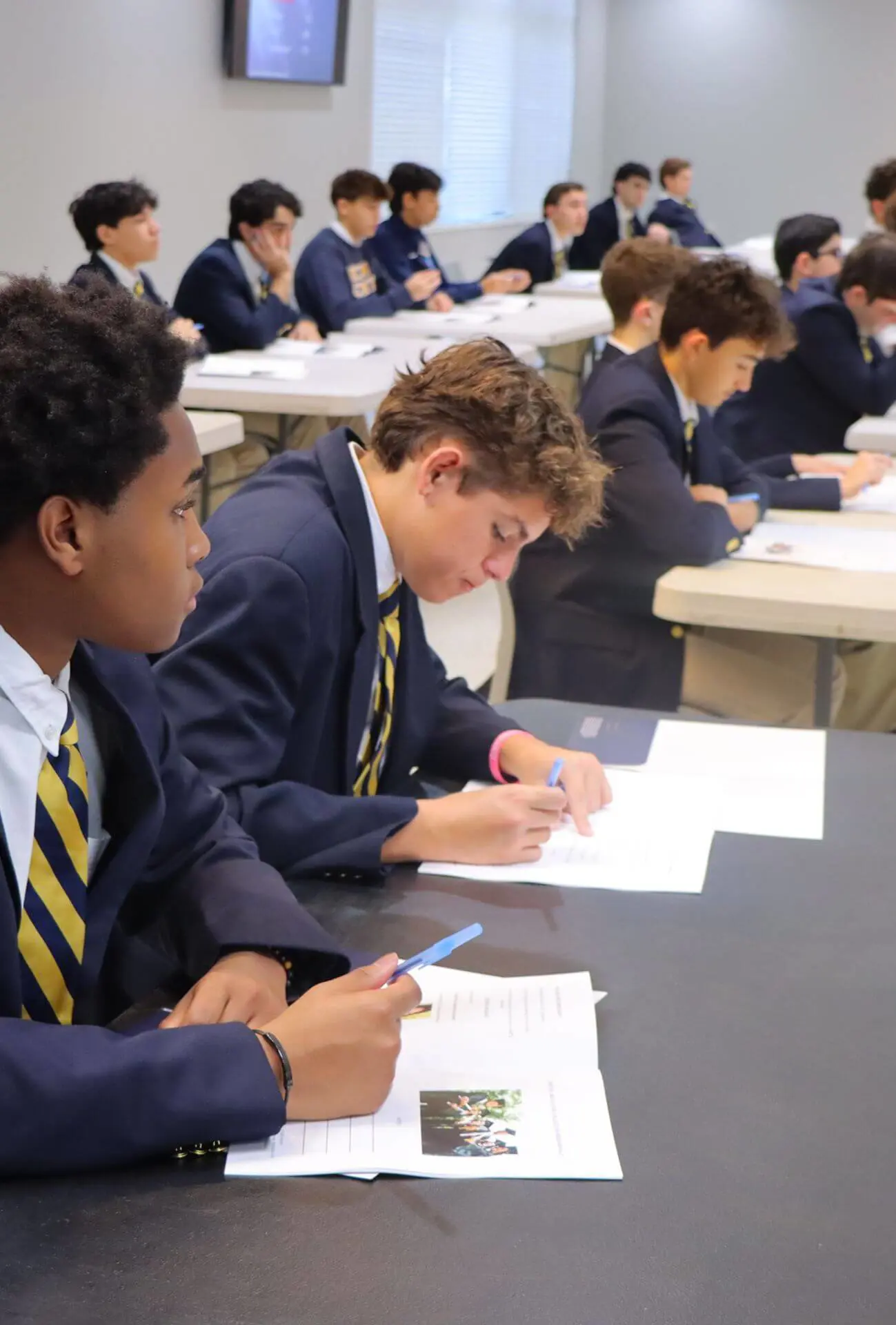 Belen Jesuit High School students seated at tables and listening attentively during the Ignatian Gentlemen Series.