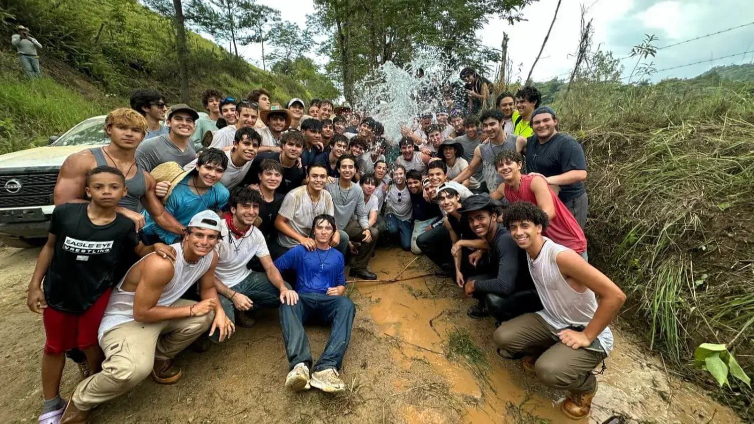 Students who attended the Belen Youth Missions trip in Janey in the Dominican Republic celebrate water going through the pipe of the aqueduct they built.