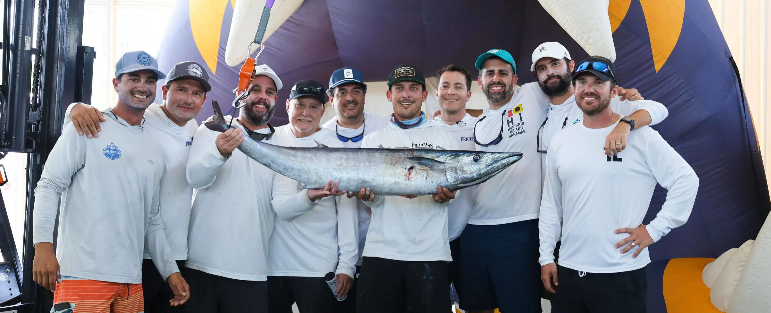 Participants in the Father Sardiña, S.J. Memorial Fishing Tournament and Dock Party posing for a photograph with a fish.