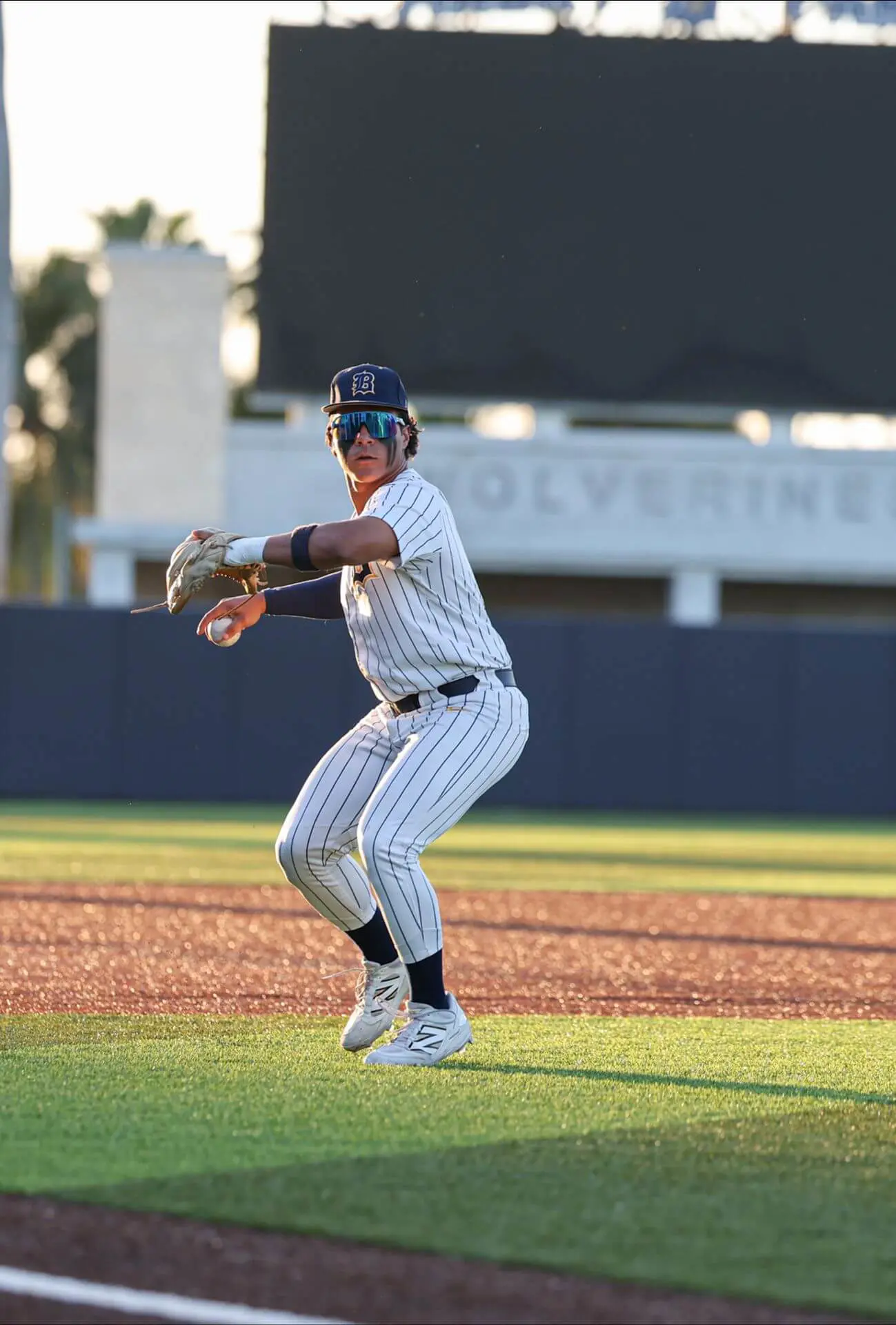 A Belen Jesuit varsity baseball player throws a ball from the outfield.