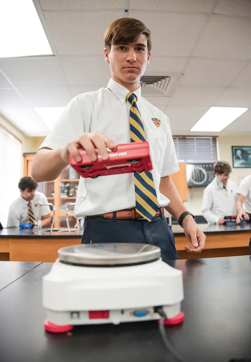 Belen Jesuit student conducts an experiment in an AP Physics class.