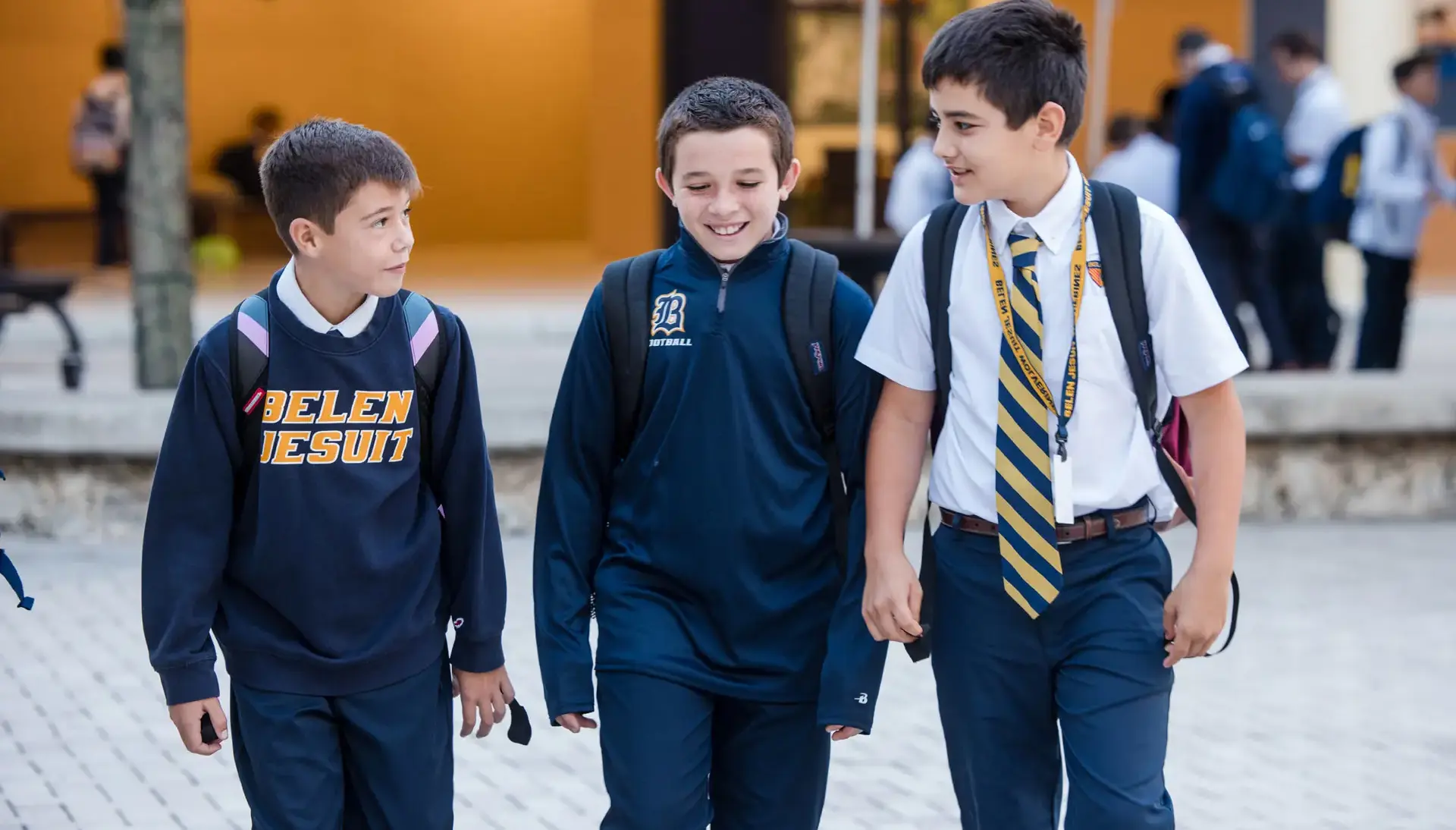 Belen Jesuit Middle School students smiling and laughing while they walk across campus together.