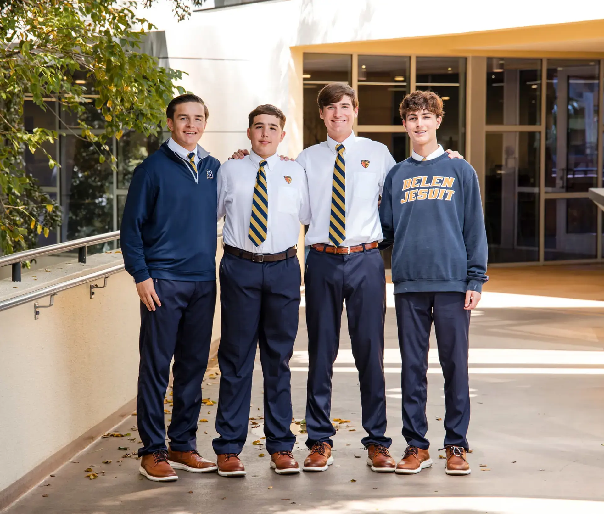 Belen Jesuit students smile for a photograph outside in the sunshine.