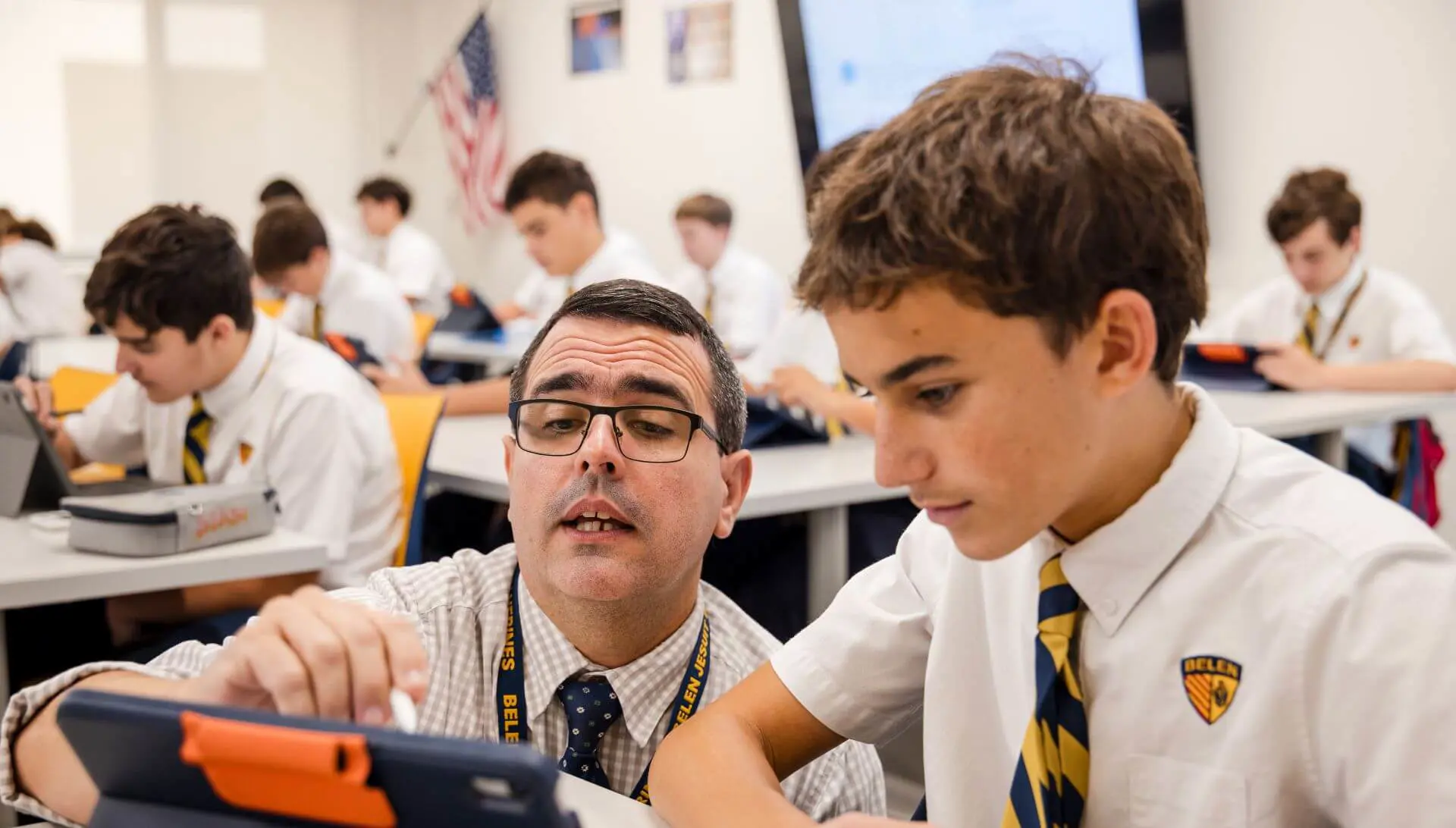 Belen Jesuit teacher helping a Middle School student with classwork.
