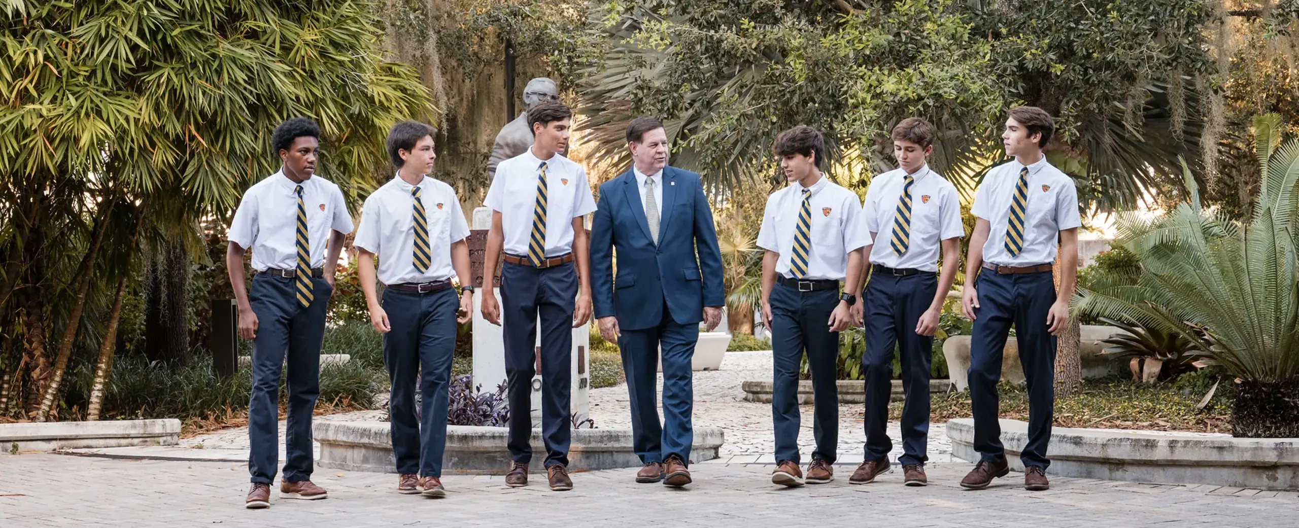 Belen Jesuit students walking across campus with the Principal.