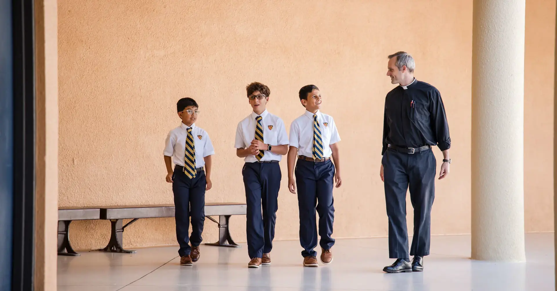 Belen Jesuit students walking across campus with a Spiritual Counselor.