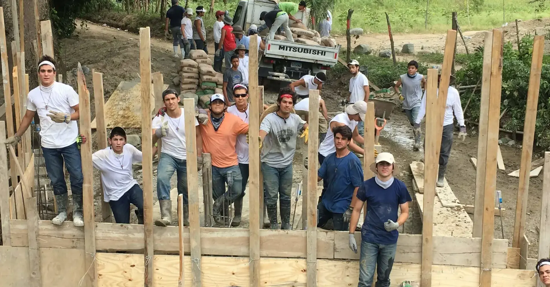 Students participating in the 2017 Belen Youth Mission posing for a photograph with the foundations of the building  they are constructing.