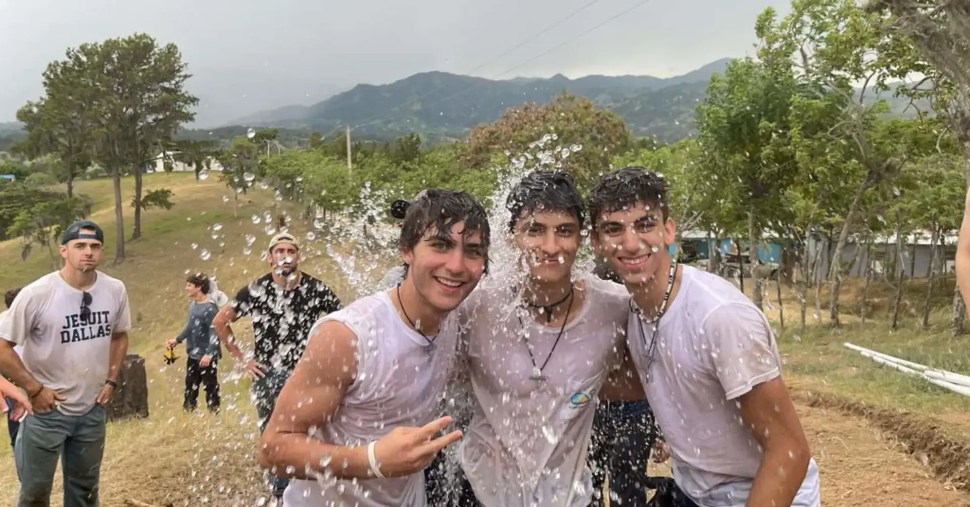 Students participating in the 2022 Belen Youth Mission being sprayed with water and laughing.