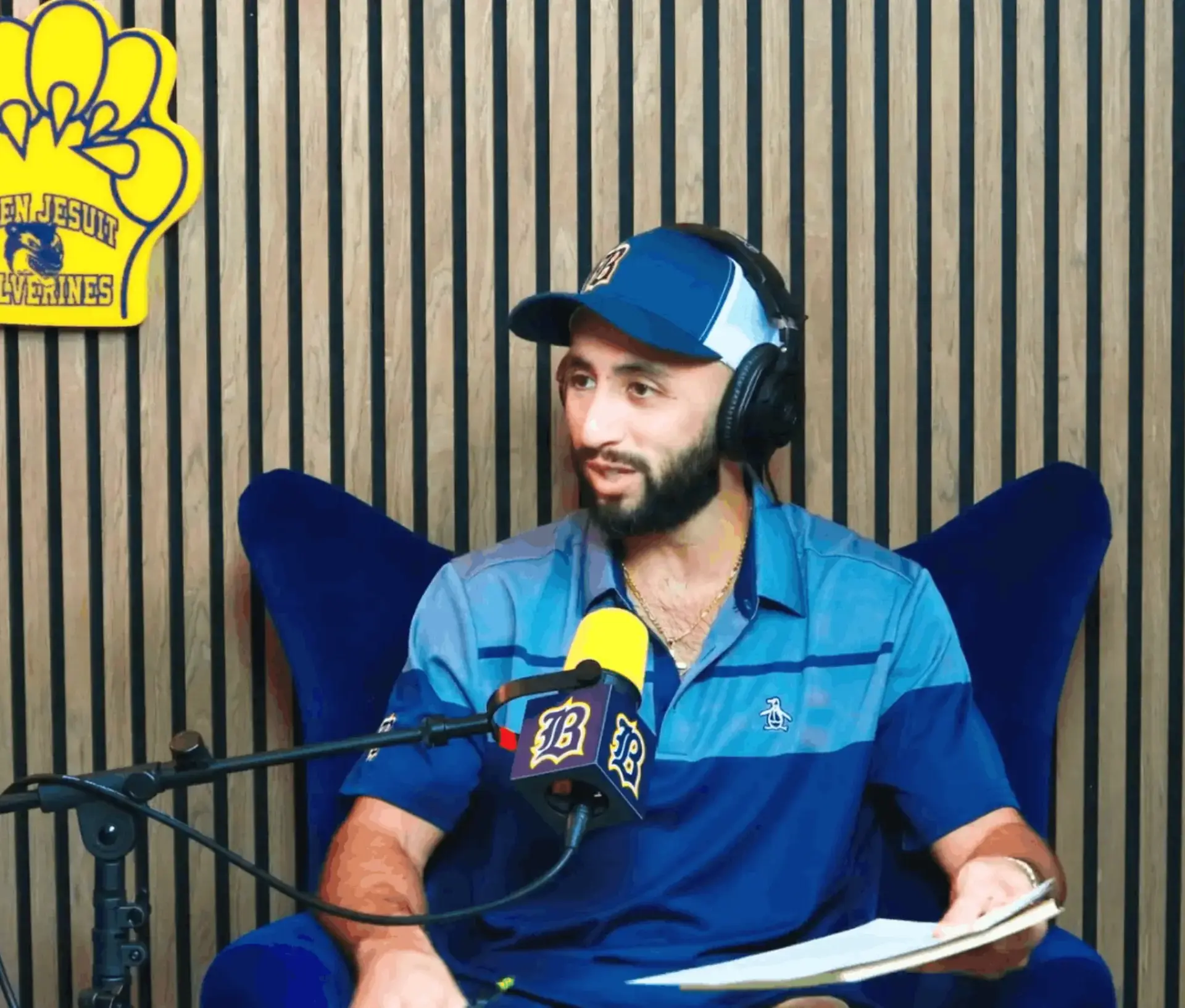  Because Belen Podcast host Bryan Herrera, class of 2006, is talking into a microphone in a studio recording an episode.