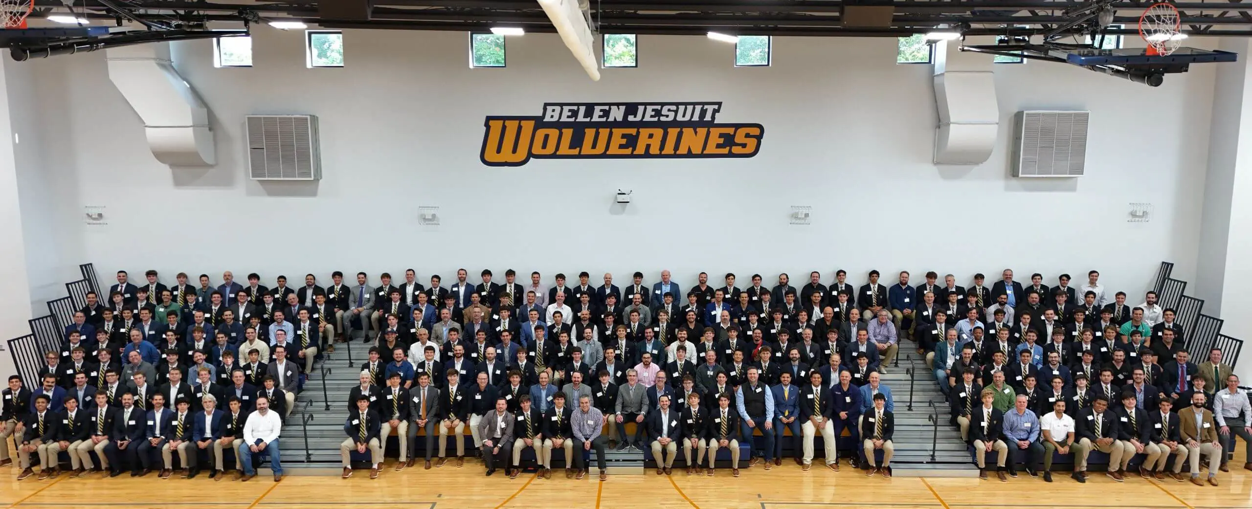 Belen Jesuit students and visitors sitting in the gymnasium for a group photograph