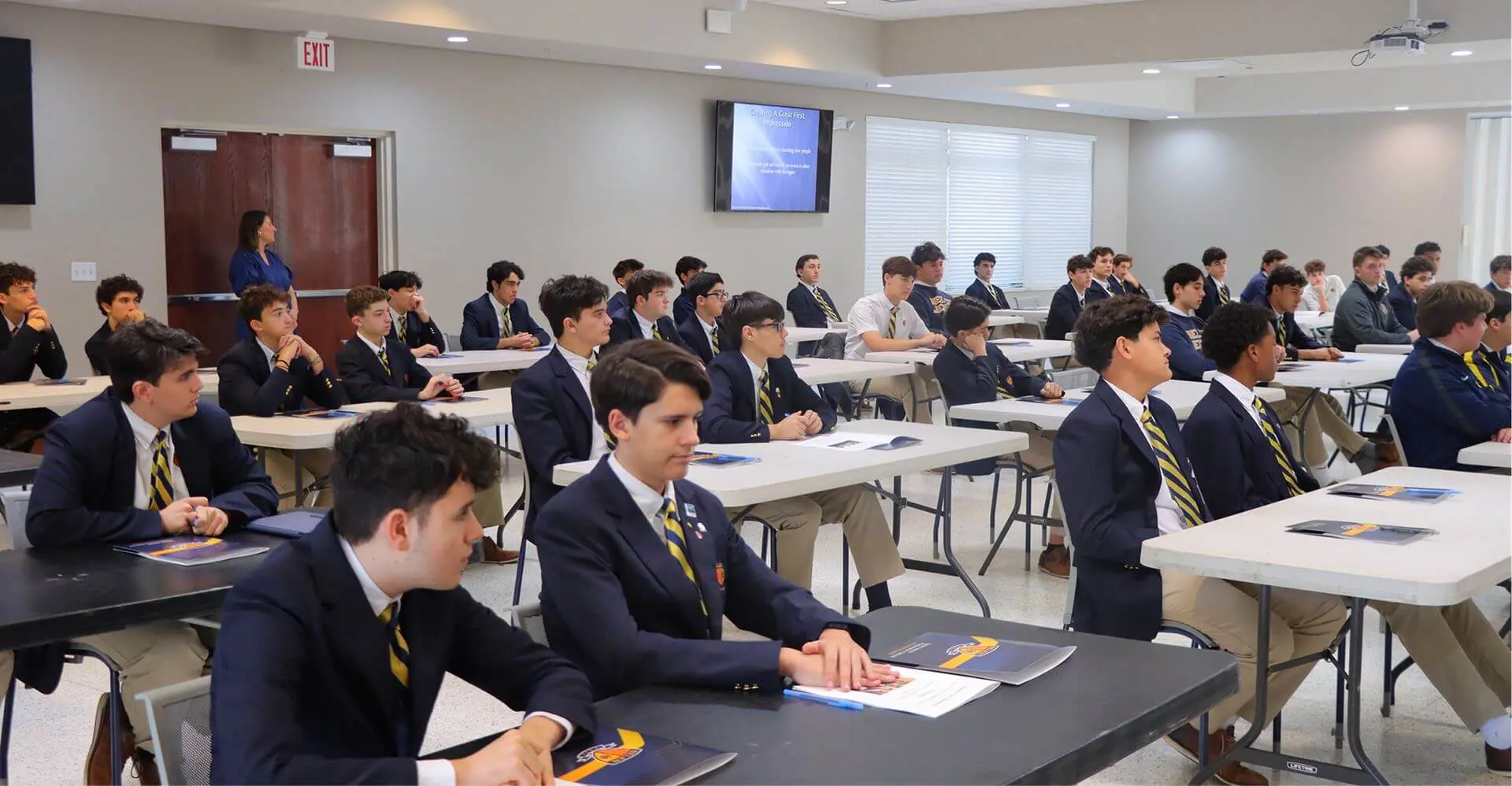 Belen Jesuit students dressed in special dress uniform are seated at tables inside the Cosculluela Hall, preparing for the Ignatian Gentlemen Series event.