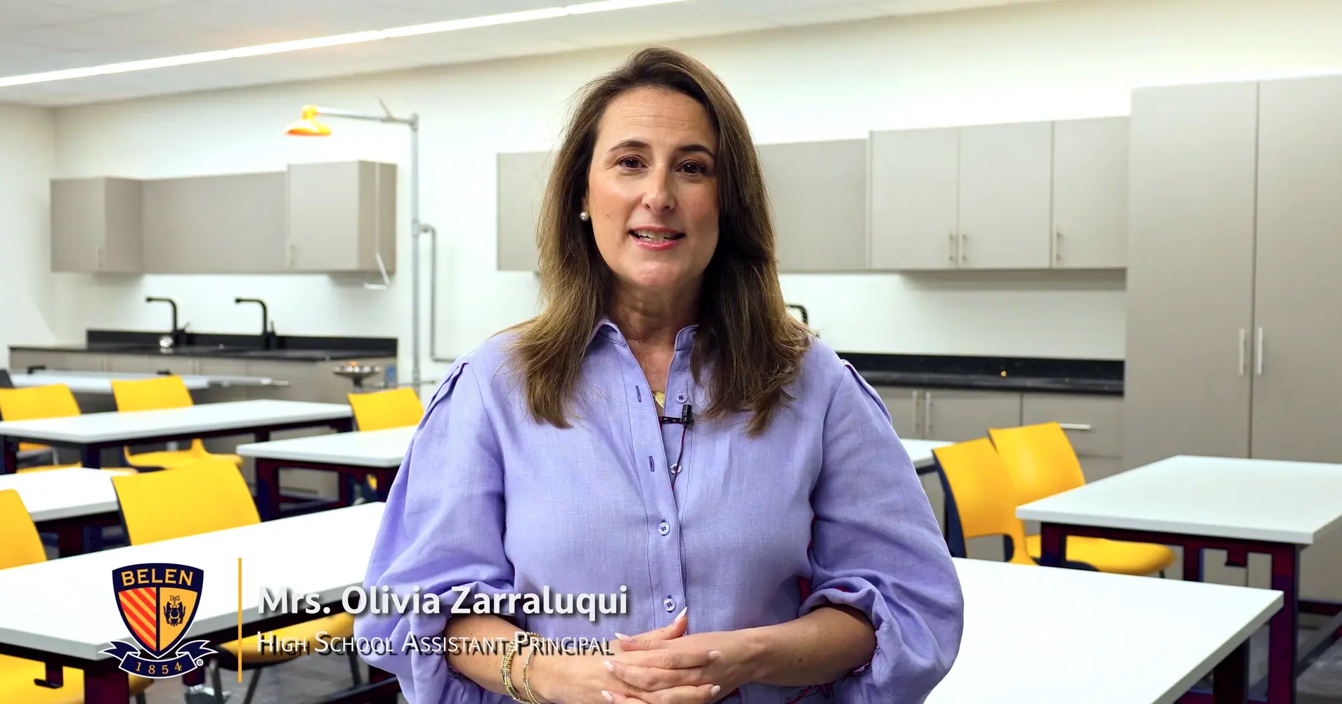 Belen Jesuit teacher Olivia Zarraluqui, smiling, standing in classroom.