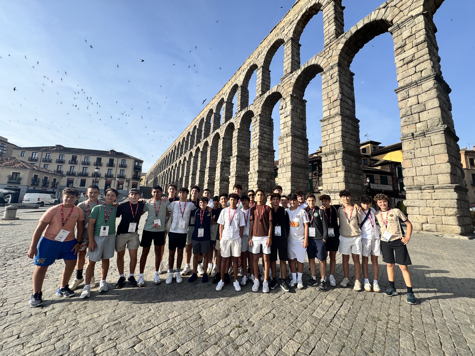 Belen Jesuit students standing by an ancient aqueduct in Spain.