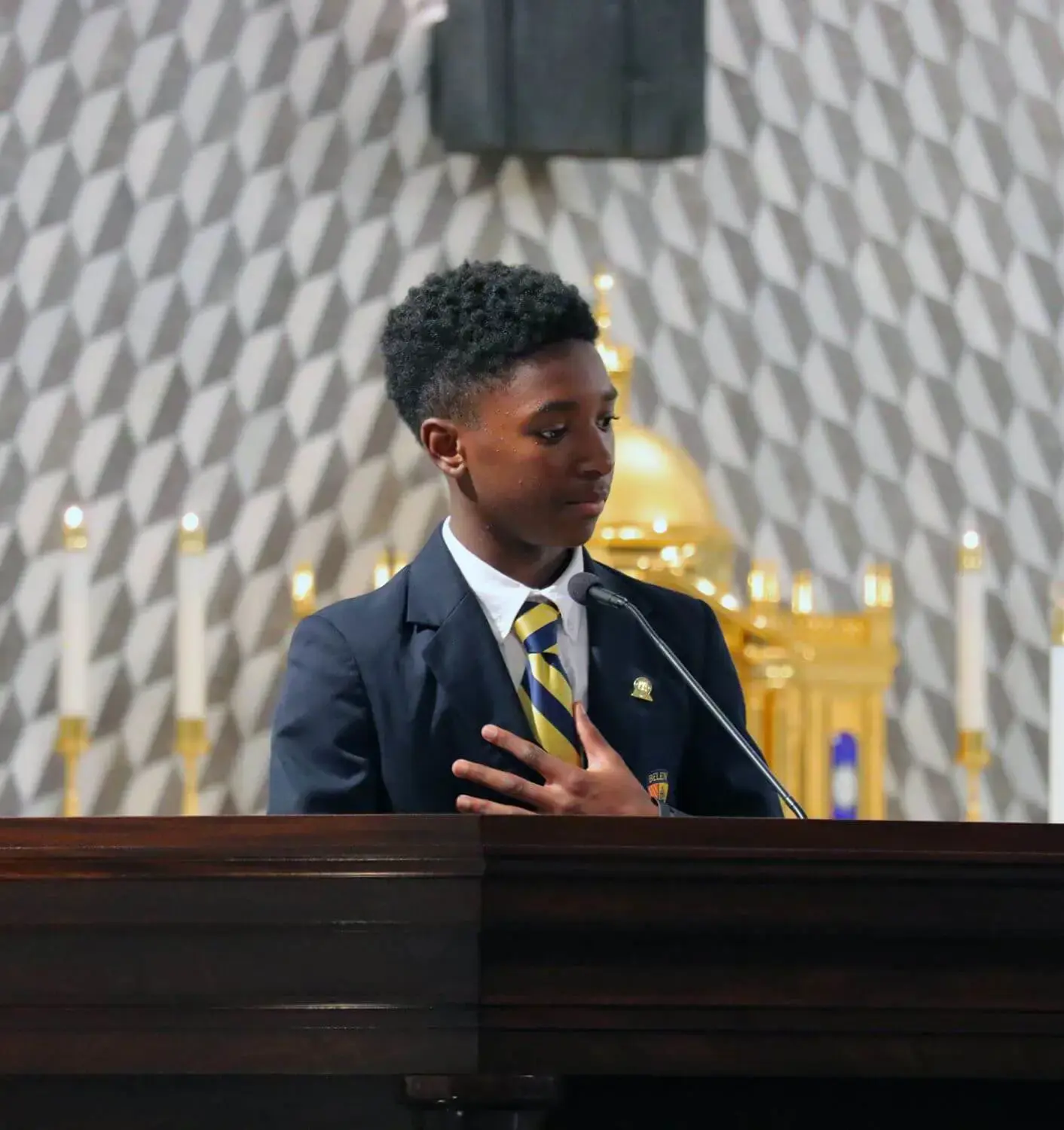 Winston Eli Burris address his classmates from the ambo at the Our Lady of Belen Chapel during the class of 2029 pin ceremony.
