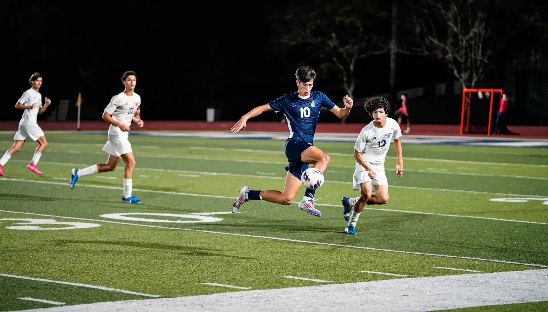 Belen Jesuit student running across the pitch during a soccer game.