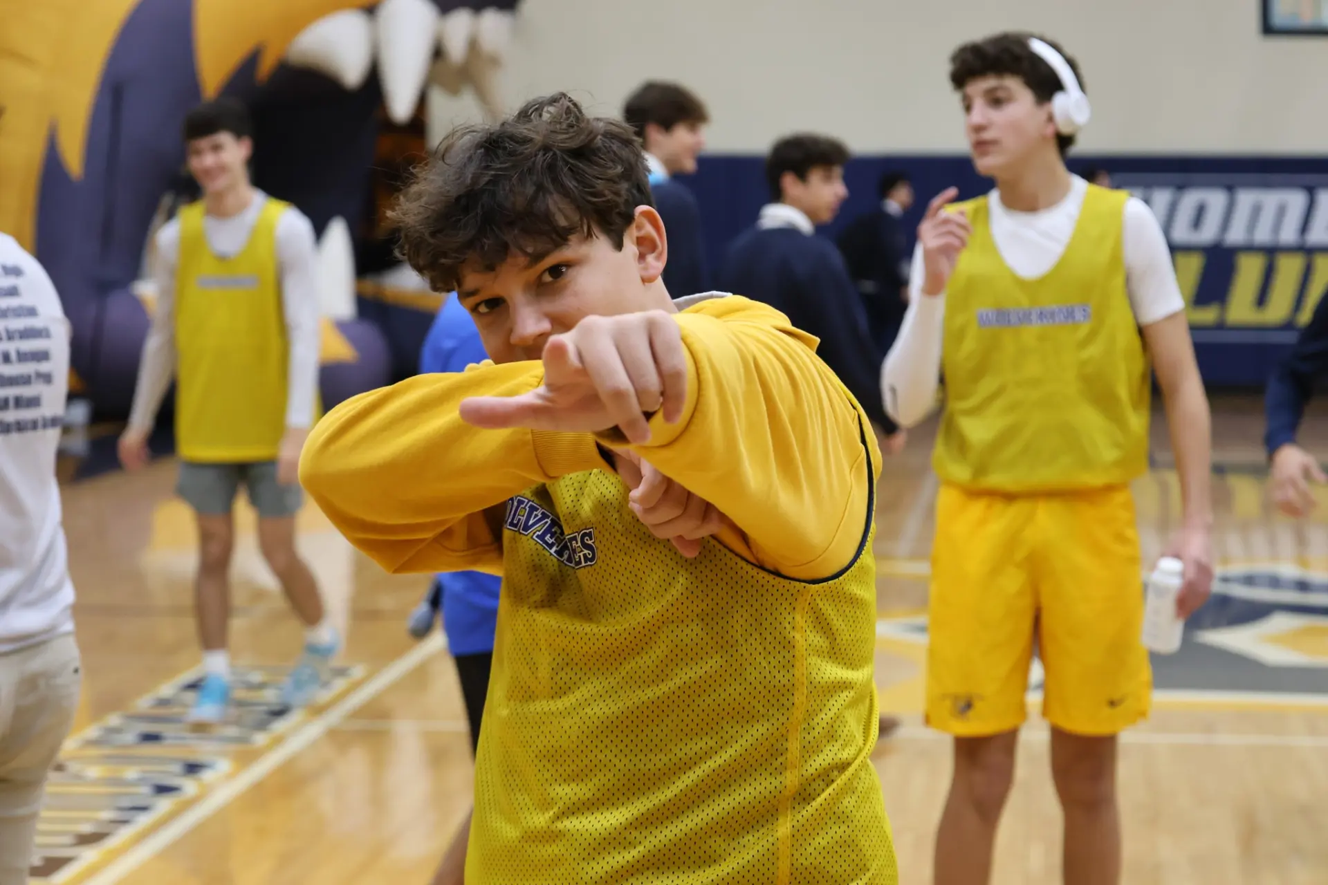 Belen Jesuit student points at the camera during a sports game.